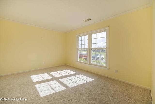 carpeted spare room with crown molding, visible vents, and baseboards