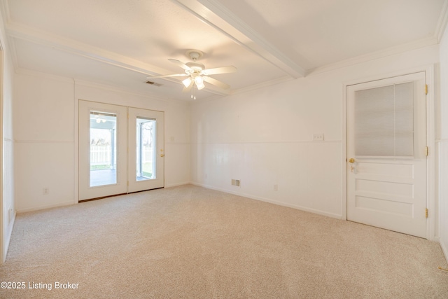 carpeted spare room featuring ceiling fan, baseboards, ornamental molding, and beam ceiling