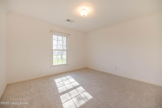 carpeted spare room featuring crown molding, visible vents, and baseboards