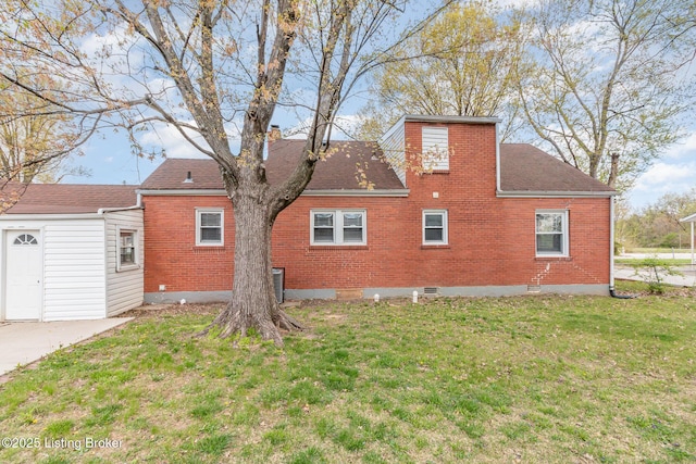 rear view of house with crawl space, a yard, a shingled roof, and brick siding