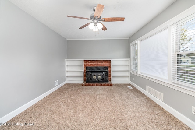 unfurnished living room with visible vents, baseboards, carpet flooring, and a wealth of natural light