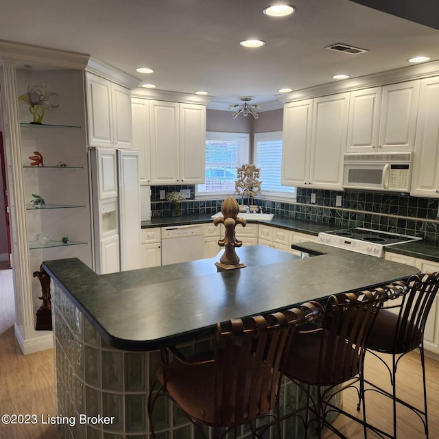 404 Eastgate Village Wynde, Louisville, KY 40223 - kitchen featuring light wood-type flooring, dark countertops, white appliances, white cabinetry, and a kitchen island