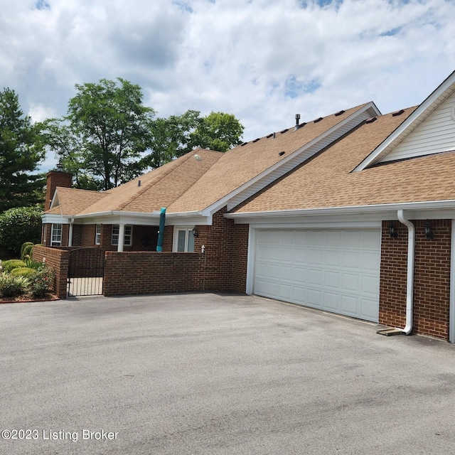 404 Eastgate Village Wynde, Louisville, KY 40223 - view of front of property with roof with shingles, a chimney, an attached garage, aphalt driveway, and brick siding
