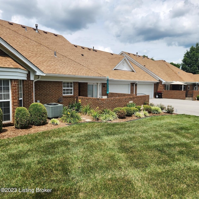 404 Eastgate Village Wynde, Louisville, KY 40223 - view of front of property featuring central air condition unit, an attached garage, concrete driveway, brick siding, and a front lawn