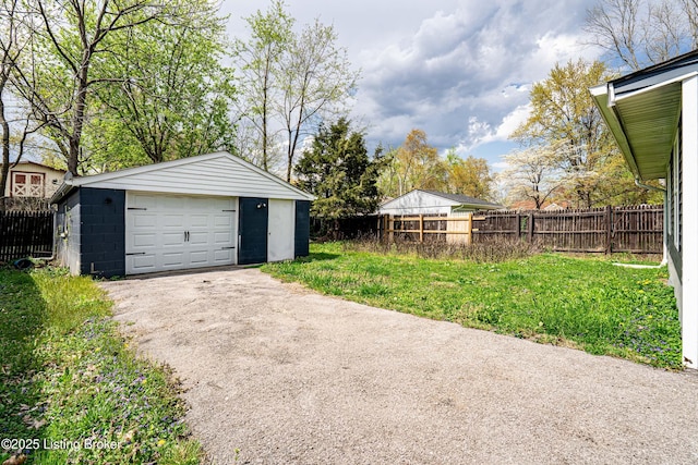 detached garage featuring fence and driveway