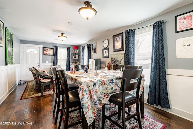 dining space with a wainscoted wall and wood finished floors