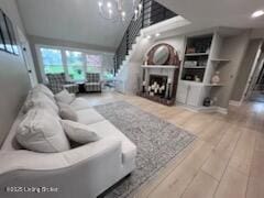 119 Fairway Dr, Hodgenville, KY 42748 - living area featuring a chandelier, wood finished floors, a fireplace, and stairs