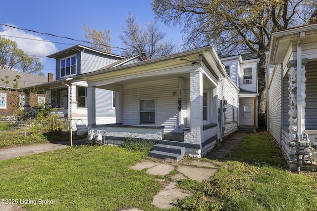 view of front of house with fence, a front lawn, and covered porch