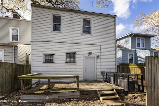 rear view of property with fence and a deck