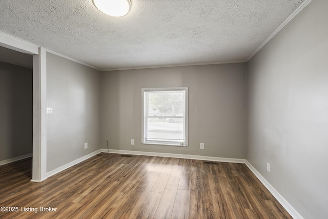 spare room featuring ornamental molding, baseboards, dark wood-style flooring, and a textured ceiling