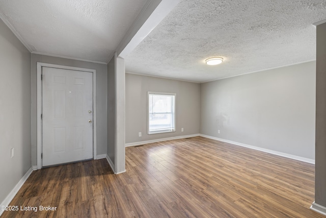 foyer featuring wood finished floors, a textured ceiling, and baseboards