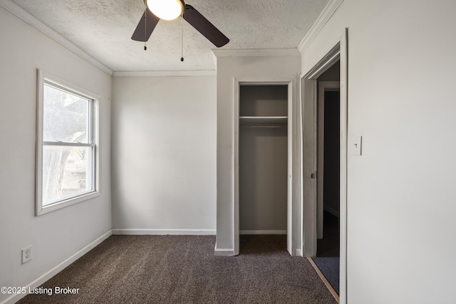 unfurnished bedroom featuring dark carpet, a ceiling fan, crown molding, baseboards, and a textured ceiling