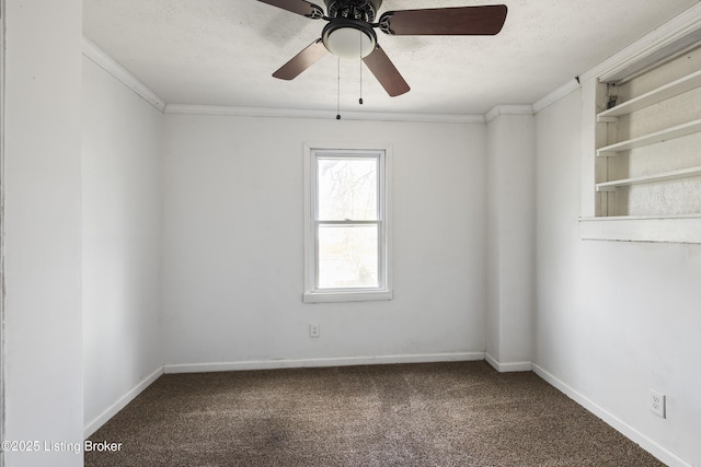 carpeted empty room with a textured ceiling, crown molding, baseboards, and ceiling fan