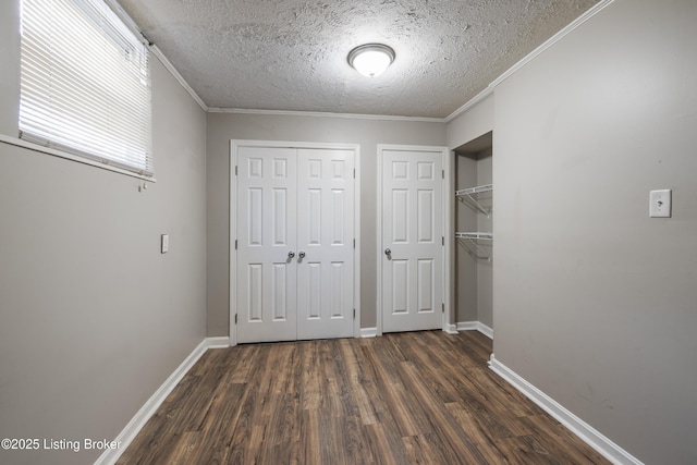 unfurnished bedroom featuring a textured ceiling, baseboards, multiple closets, and dark wood-style floors
