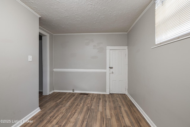 empty room with wood finished floors, a textured ceiling, and baseboards