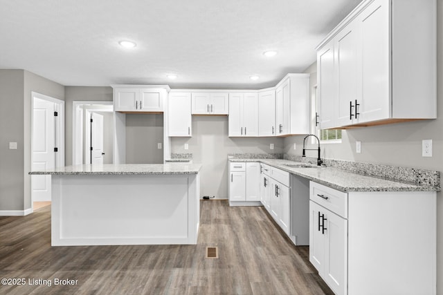 3408 Rhodelia Rd, Payneville, KY 40157 - kitchen featuring wood finished floors, a center island, white cabinets, and recessed lighting