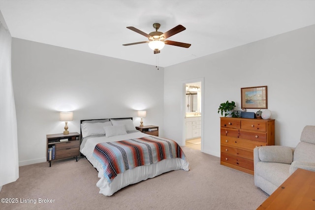 carpeted bedroom with ensuite bathroom, baseboards, and ceiling fan