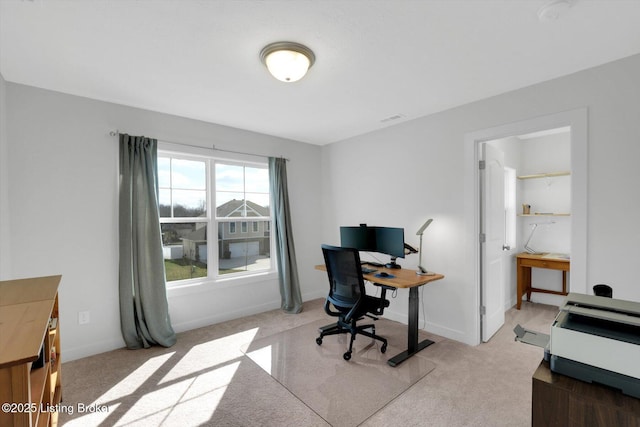 office featuring light colored carpet, baseboards, and visible vents