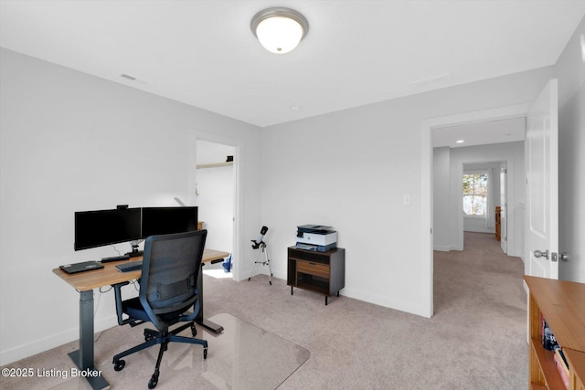 office featuring light carpet, visible vents, and baseboards