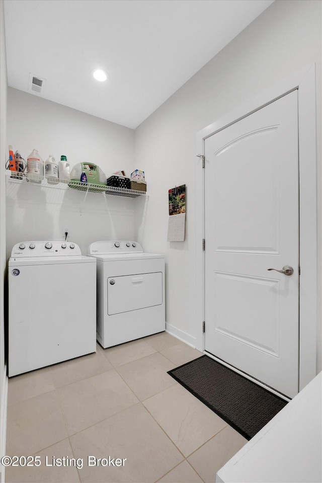 laundry room with baseboards, light tile patterned floors, visible vents, laundry area, and washing machine and clothes dryer