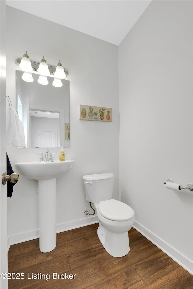 bathroom featuring baseboards, toilet, and wood finished floors