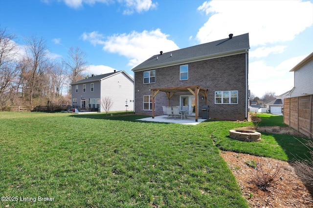 back of house with a yard, an outdoor fire pit, a patio area, fence, and brick siding