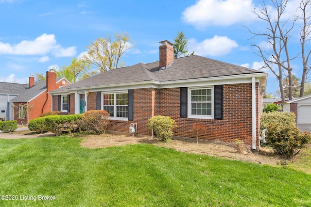 view of front of home with a chimney, a shingled roof, a front yard, and brick siding