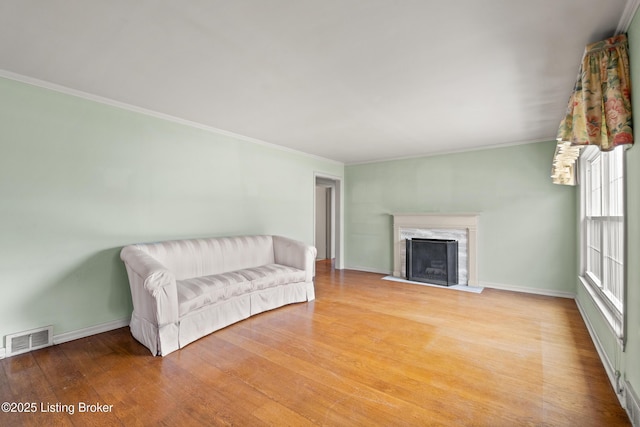 interior space featuring a wealth of natural light, a high end fireplace, visible vents, and wood finished floors