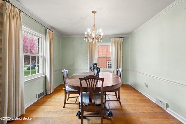 dining space featuring visible vents, an inviting chandelier, and light wood-style flooring