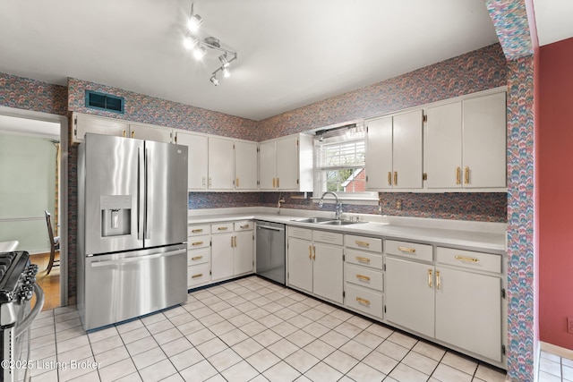 kitchen featuring a sink, light countertops, white cabinetry, stainless steel appliances, and light tile patterned flooring