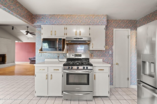 kitchen with stainless steel appliances, under cabinet range hood, and wallpapered walls