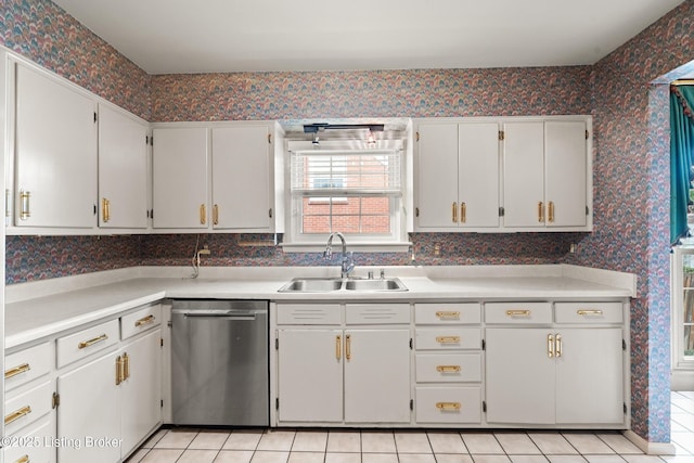 kitchen featuring a sink, light countertops, white cabinetry, wallpapered walls, and stainless steel dishwasher