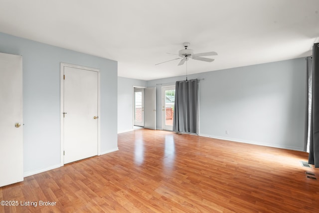 unfurnished room with light wood-type flooring, baseboards, a ceiling fan, and visible vents