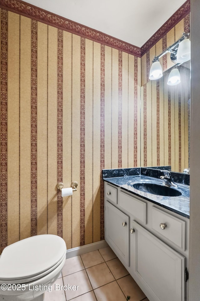half bathroom with wallpapered walls, toilet, tile patterned flooring, and vanity