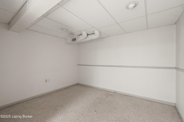 carpeted empty room featuring visible vents, baseboards, and a drop ceiling