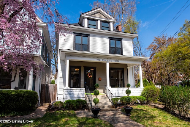 american foursquare style home featuring a porch
