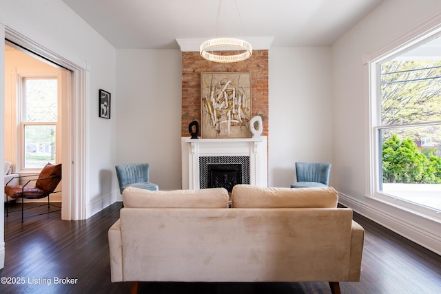 living room featuring plenty of natural light, a tile fireplace, dark wood-style floors, and baseboards