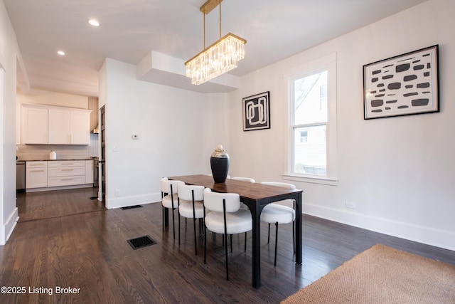 dining area with visible vents, baseboards, an inviting chandelier, and dark wood finished floors