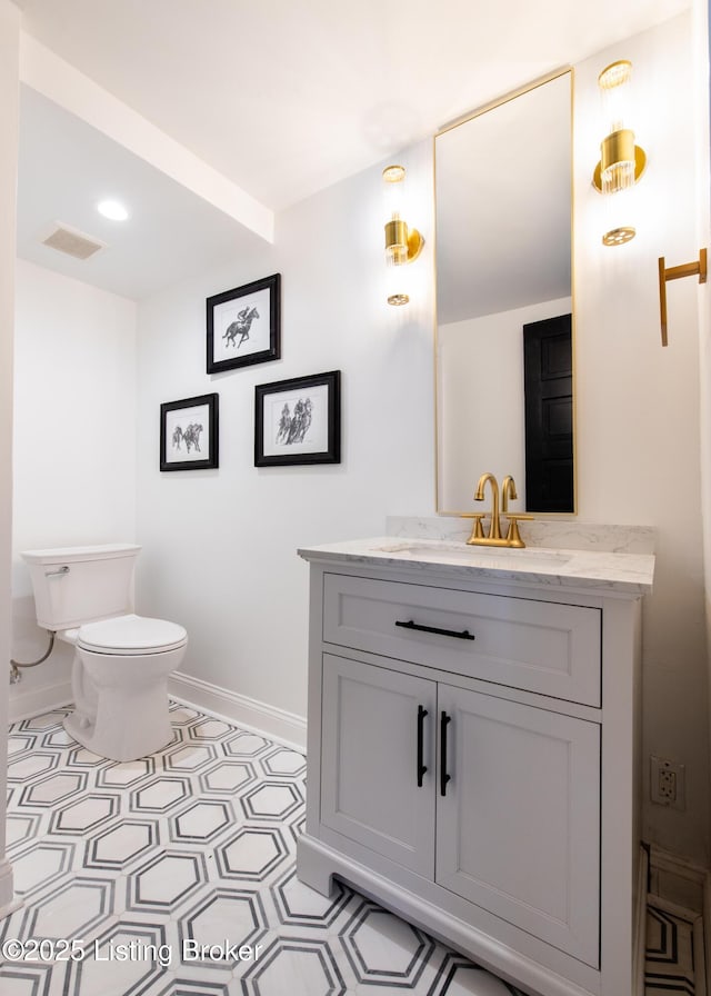 bathroom featuring visible vents, baseboards, toilet, vanity, and tile patterned flooring