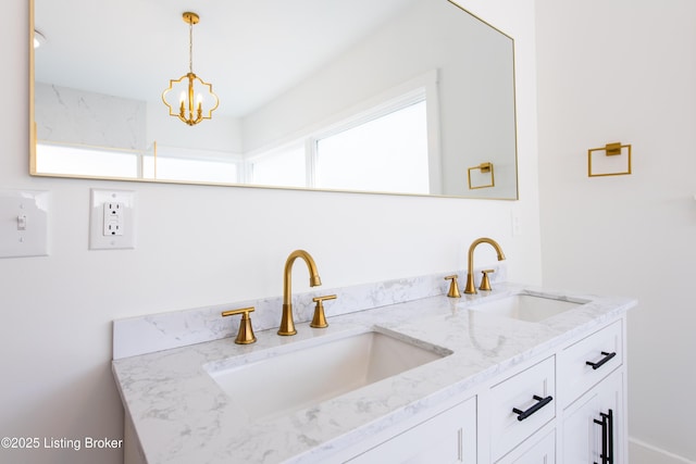 full bath featuring a chandelier, double vanity, and a sink