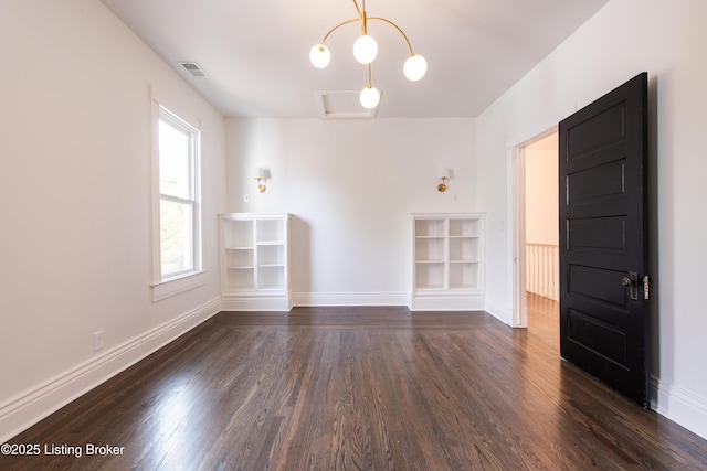 unfurnished room featuring dark wood-style flooring, visible vents, and baseboards