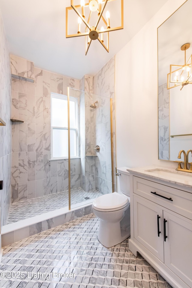 full bathroom featuring toilet, tiled shower, a chandelier, and vanity