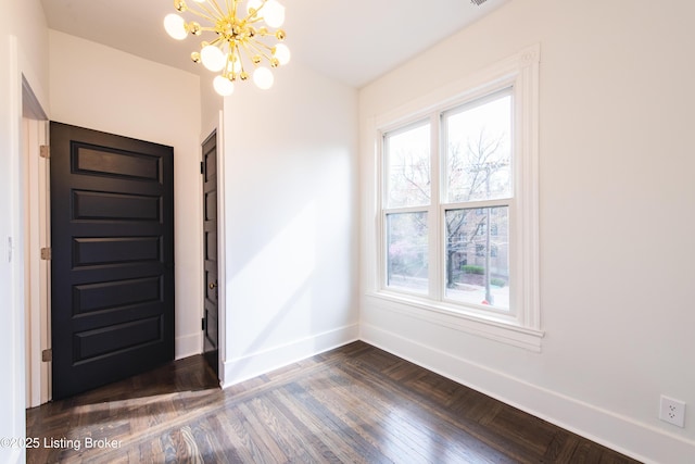 foyer with baseboards, an inviting chandelier, and parquet flooring