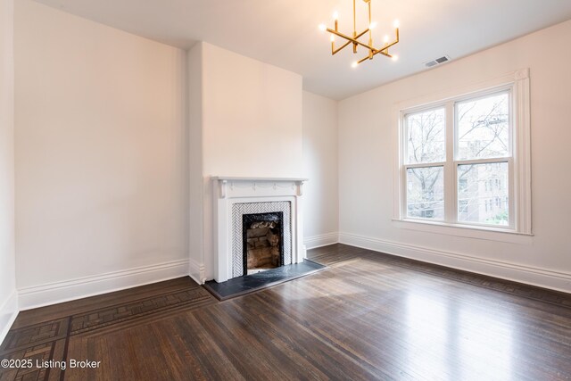 unfurnished living room with a chandelier, a tiled fireplace, baseboards, and visible vents