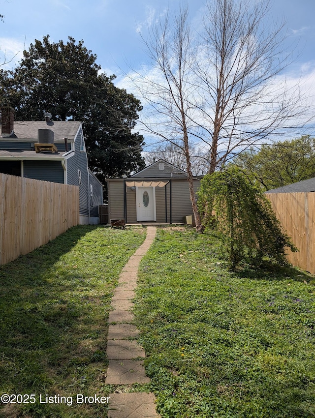 view of yard featuring cooling unit, fence private yard, and an outdoor structure