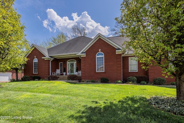 view of front of property featuring roof with shingles, brick siding, and a front lawn