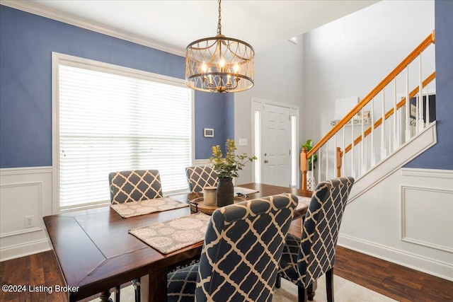 dining space featuring stairs, wainscoting, an inviting chandelier, and wood finished floors