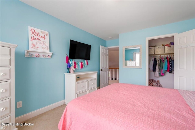 bedroom featuring a closet, baseboards, a walk in closet, and light colored carpet