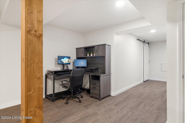 office featuring baseboards, recessed lighting, a barn door, and wood finished floors