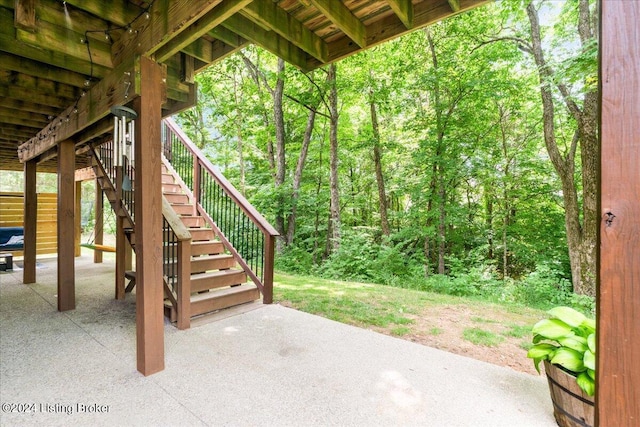 view of patio / terrace featuring a forest view and stairs